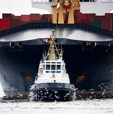 Lotsenboot zieht Containerschiff